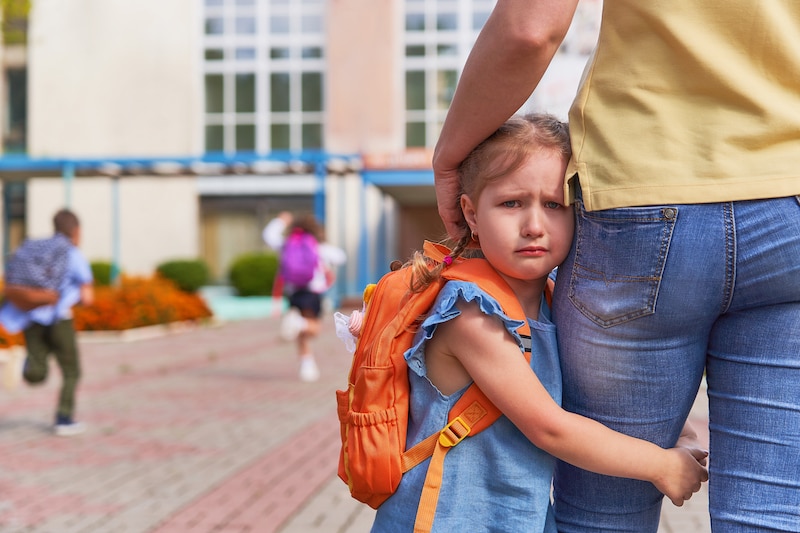 kid clinging onto parent's leg