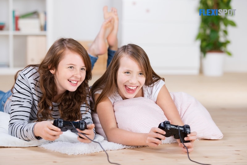 Two young girls happily playing video games
