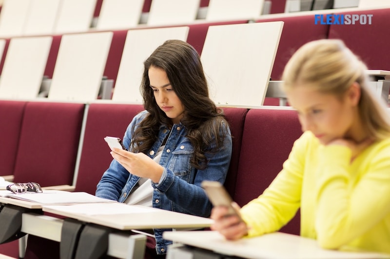 Schoolgirl with smartphone on lecture