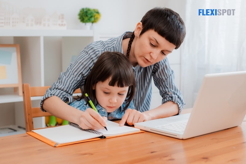 Mom and children are doing homework on laptop computers at home