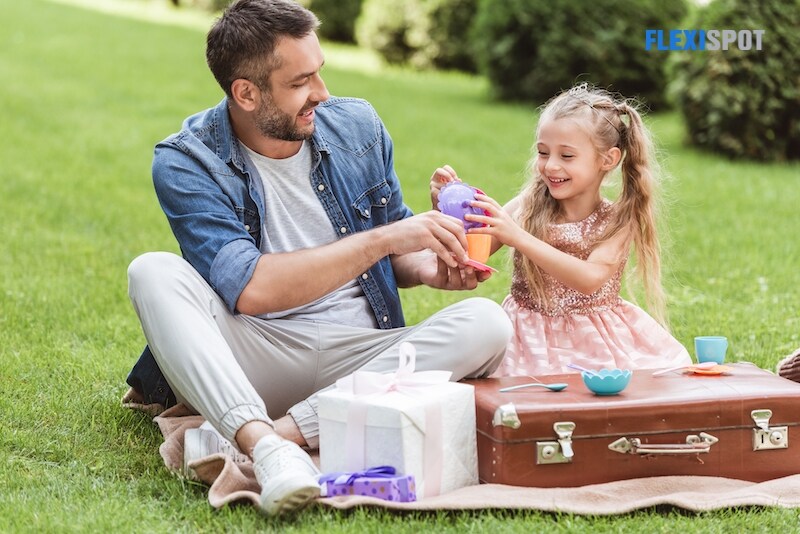 Father and daughter playing tea party on the lawn