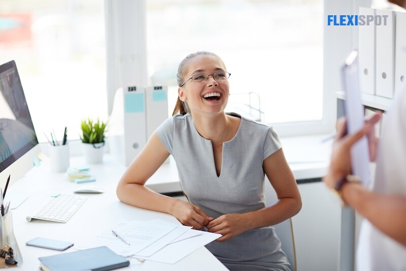 Businesswoman laughing during conversation with co-worker